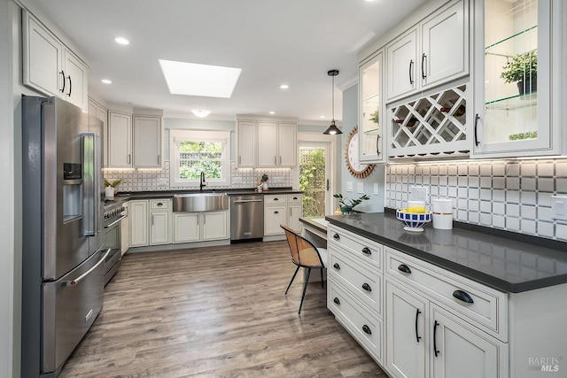 kitchen with appliances with stainless steel finishes, a sink, and dark countertops