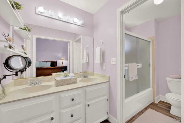 280 Park St, Concord, CA 94520 - ensuite bathroom featuring toilet, wood finished floors, double vanity, baseboards, and bath / shower combo with glass door