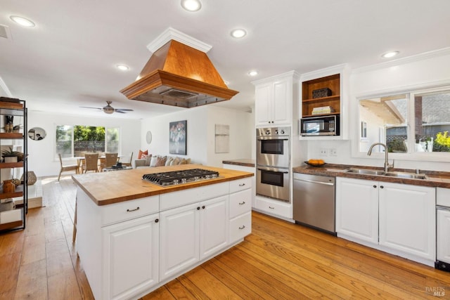 kitchen featuring wooden counters, ceiling fan, white cabinets, a sink, and appliances with stainless steel finishes