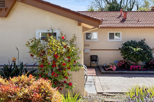 exterior space with stucco siding and a tiled roof