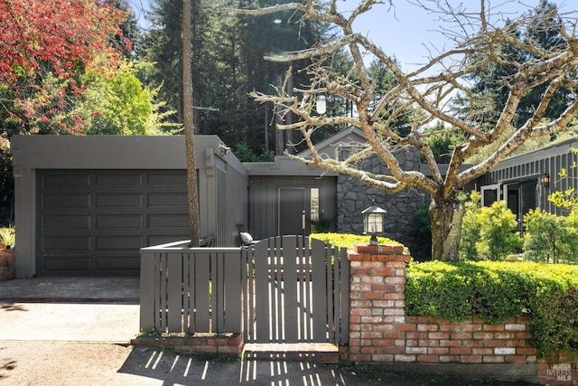 view of front of home with a gate, driveway, and an attached garage