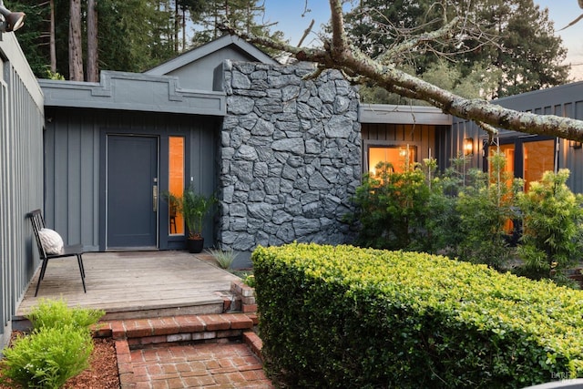 property entrance featuring stone siding and board and batten siding