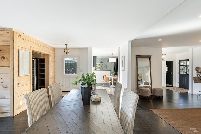 dining area featuring wooden walls and hardwood / wood-style floors