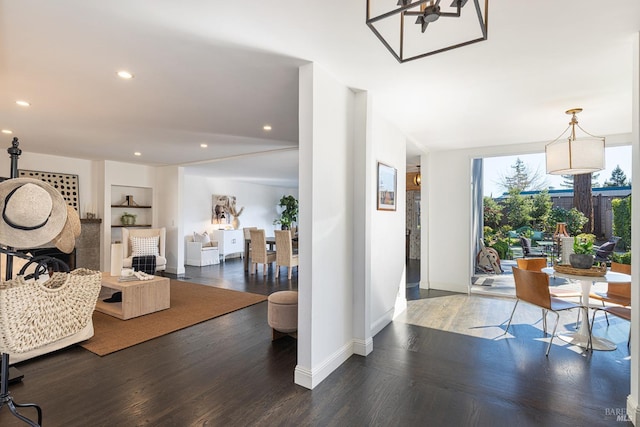 interior space with baseboards, wood finished floors, and recessed lighting