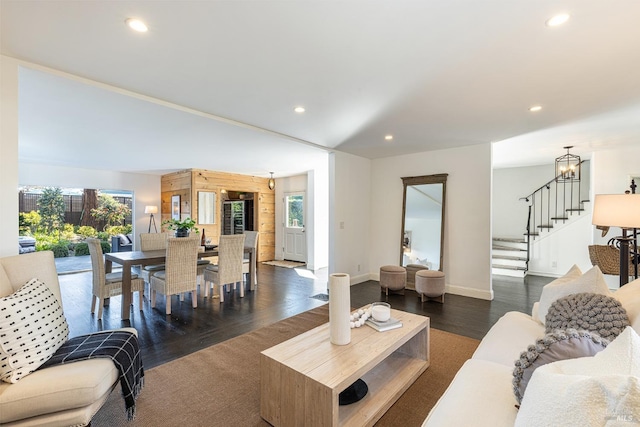 living room featuring plenty of natural light, recessed lighting, dark wood finished floors, and stairway