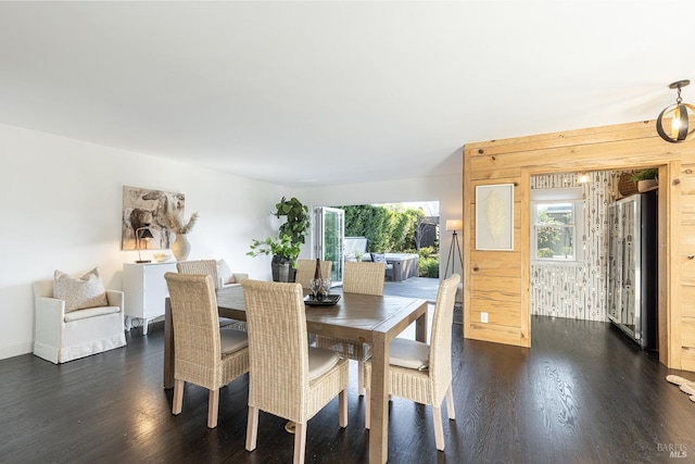 dining room with dark wood-style floors and wood walls