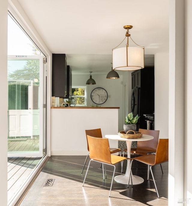 dining room with baseboards, visible vents, and dark wood finished floors