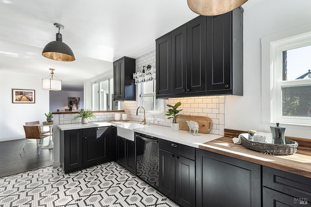kitchen featuring decorative backsplash, a wealth of natural light, a peninsula, and dishwasher