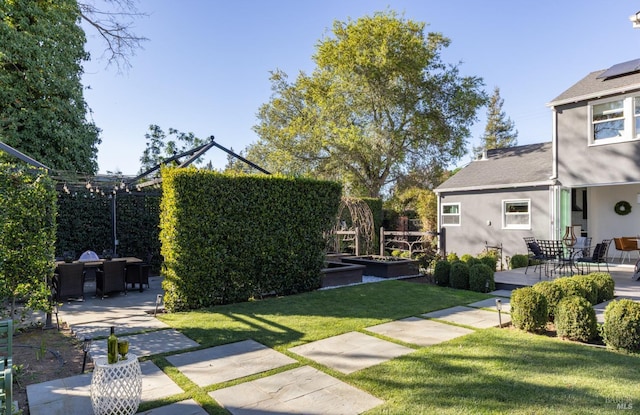 view of yard with outdoor dining area, a patio, and a garden