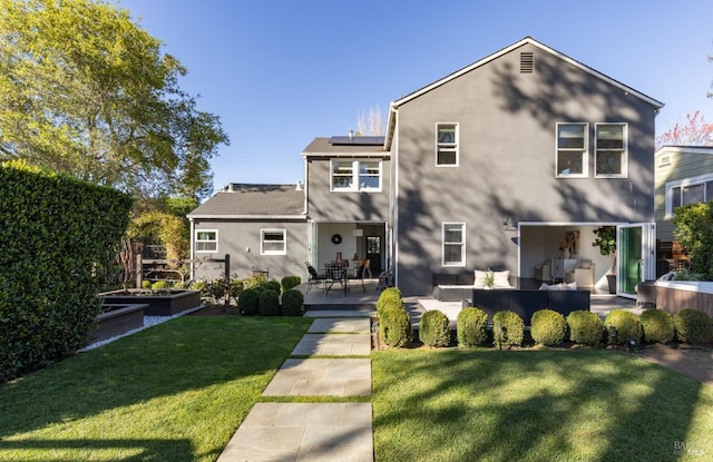 rear view of property with stucco siding, an outdoor living space, a vegetable garden, solar panels, and a lawn