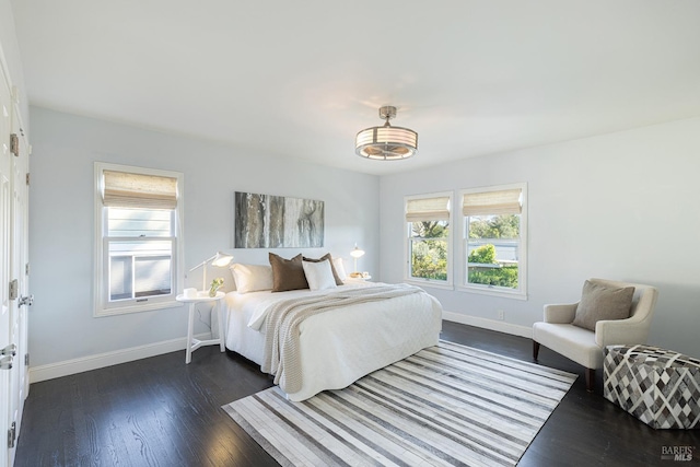 bedroom featuring dark wood finished floors and baseboards