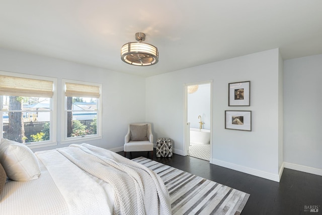 bedroom featuring baseboards, ensuite bathroom, and dark wood-style flooring