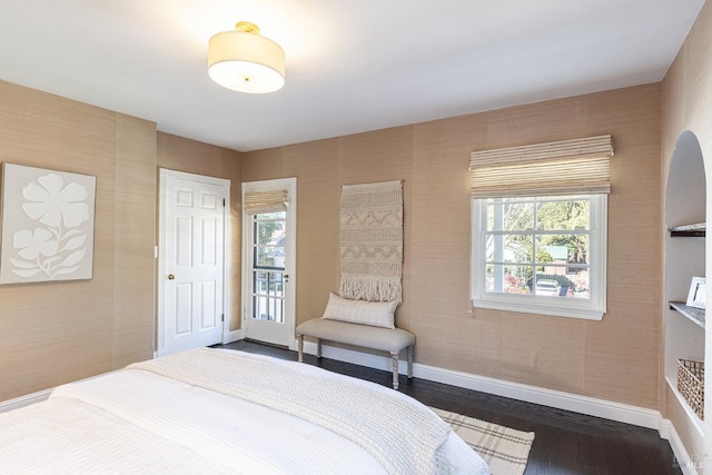 bedroom with dark wood-style floors and baseboards