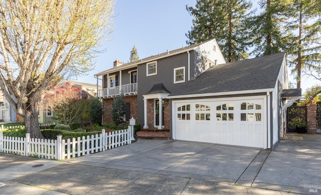 view of front of home featuring concrete driveway, an attached garage, a fenced front yard, brick siding, and a chimney
