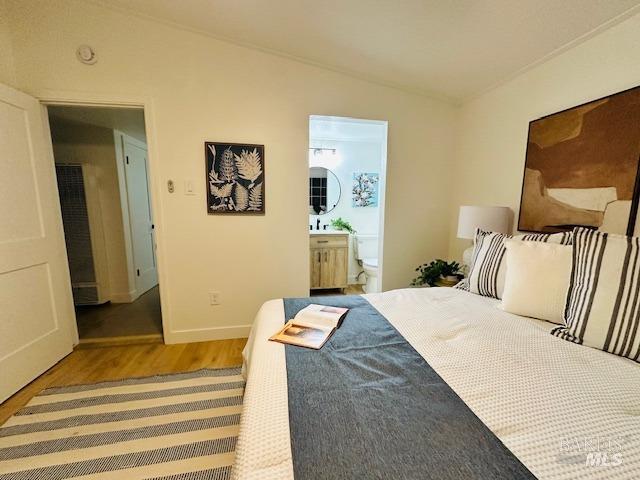 1242 Van Buren St, Fairfield, CA 94533 - bedroom featuring lofted ceiling, wood finished floors, ensuite bath, and baseboards