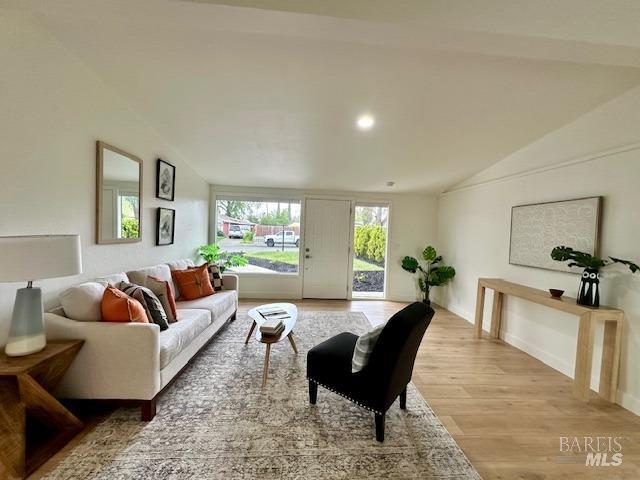 1242 Van Buren St, Fairfield, CA 94533 - living room featuring vaulted ceiling, light wood-style flooring, and baseboards