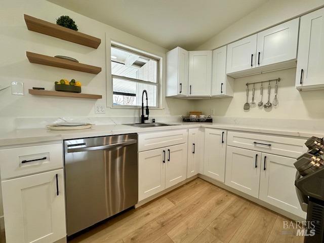 1242 Van Buren St, Fairfield, CA 94533 - kitchen featuring stainless steel dishwasher, a sink, light wood finished floors, and white cabinets
