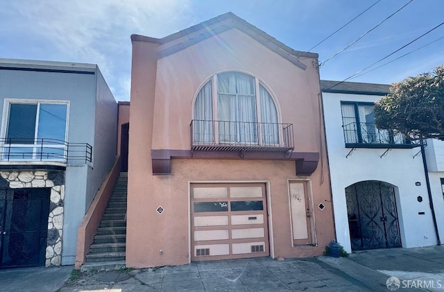 1347 Shafter Ave, San Francisco, CA 94124 - view of front of house with a balcony, stucco siding, a garage, stairs, and stone siding