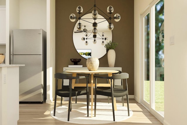 dining room featuring an inviting chandelier, light wood-style flooring, and baseboards