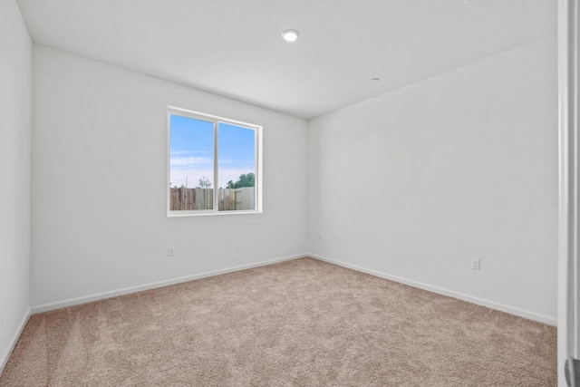 empty room featuring carpet floors and baseboards