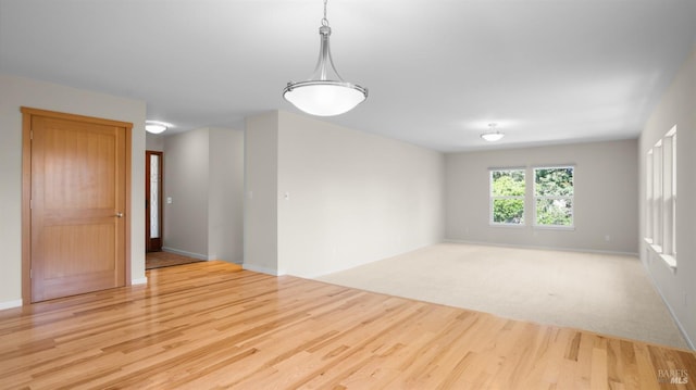 unfurnished room featuring baseboards and light wood-type flooring