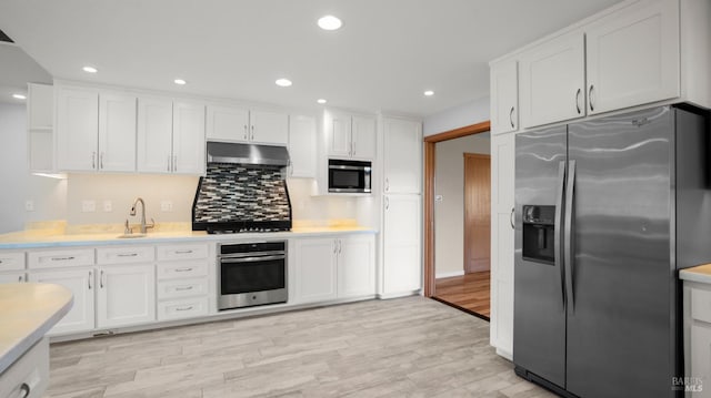 kitchen featuring light countertops, stainless steel appliances, and under cabinet range hood