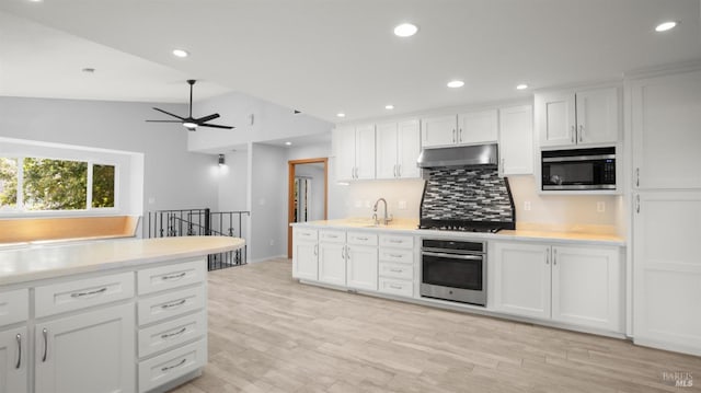 kitchen with white cabinetry, stainless steel appliances, under cabinet range hood, a sink, and ceiling fan