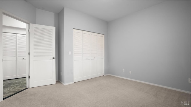 unfurnished bedroom with baseboards, carpet floors, and a closet