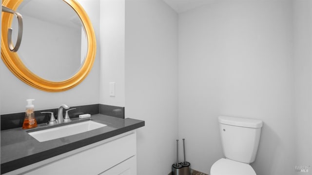 half bathroom featuring toilet and vanity