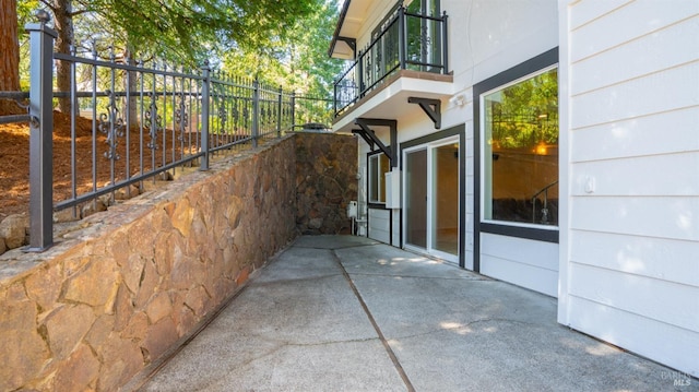 view of side of home featuring a balcony and fence