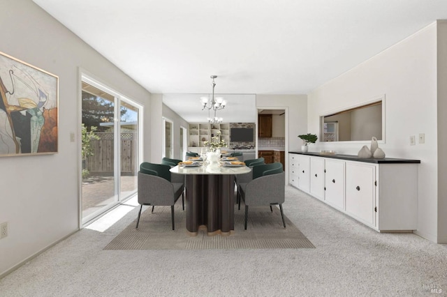 dining area featuring a chandelier and light colored carpet
