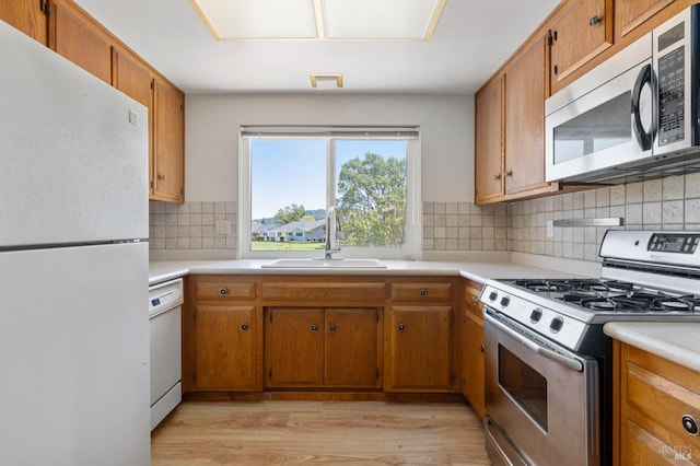 kitchen with a sink, light countertops, and appliances with stainless steel finishes