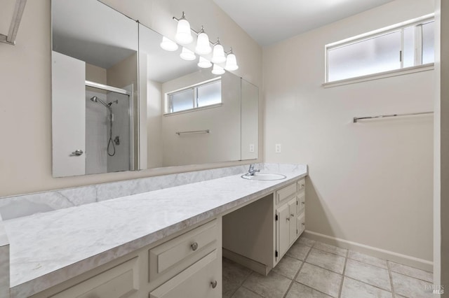 full bathroom featuring a shower stall, tile patterned floors, vanity, and baseboards