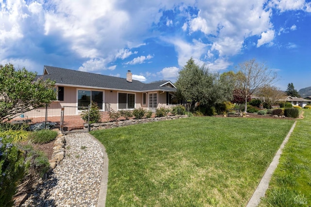 view of front of property featuring a front yard, fence, board and batten siding, and a chimney