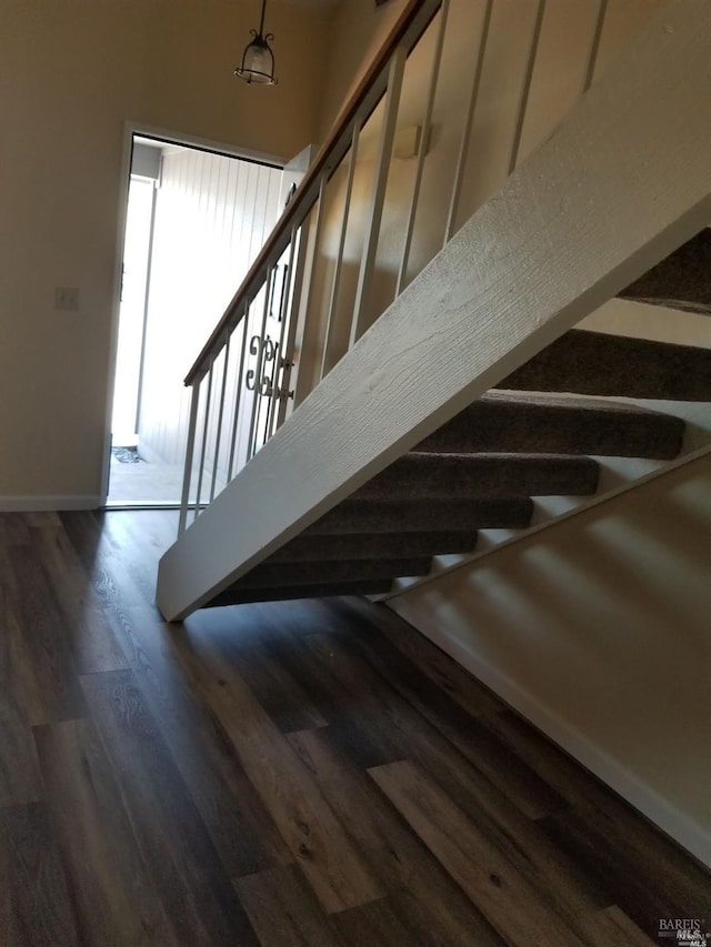staircase with baseboards and wood finished floors