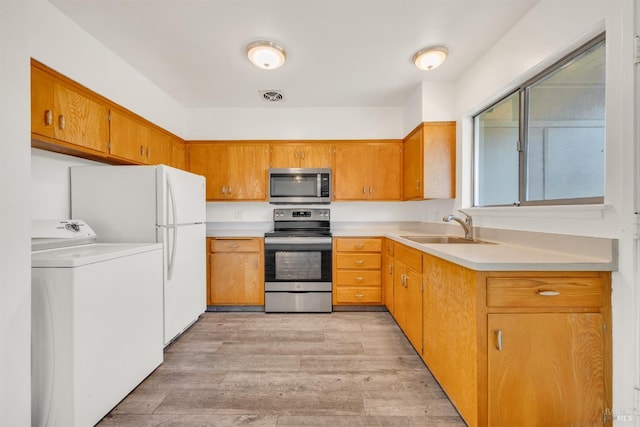 1008 Los Gamos Rd Unit F, San Rafael, CA 94903 - kitchen featuring stainless steel appliances, washer / clothes dryer, a sink, light countertops, and light wood finished floors