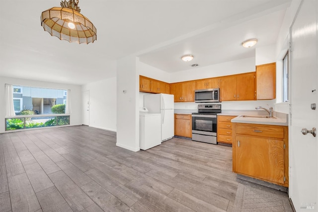 1008 Los Gamos Rd Unit F, San Rafael, CA 94903 - kitchen with appliances with stainless steel finishes, washer / dryer, a sink, light countertops, and light wood finished floors