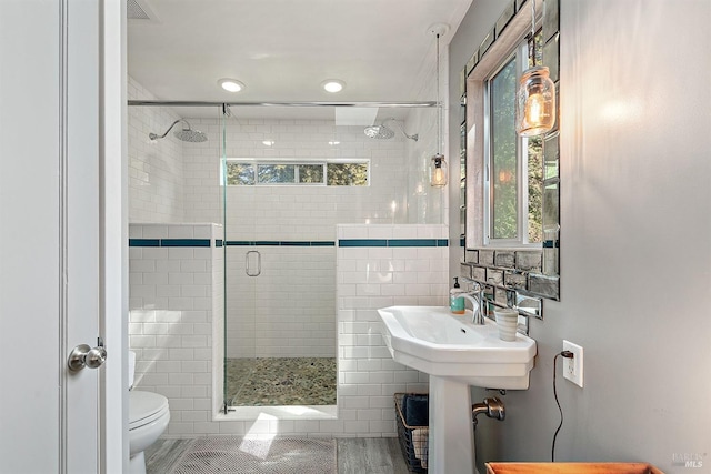 bathroom featuring a shower stall, visible vents, toilet, and a healthy amount of sunlight