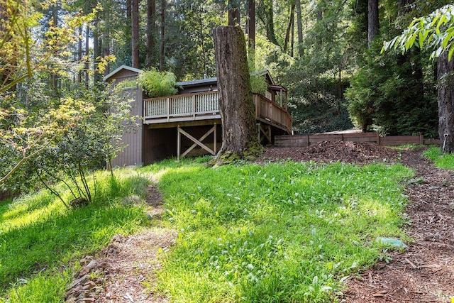 view of yard with a wooden deck and a wooded view