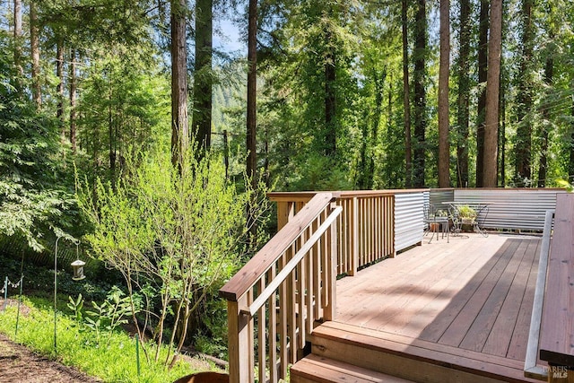 wooden deck with a wooded view