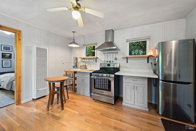 kitchen featuring gray cabinets, appliances with stainless steel finishes, light wood-style floors, and wall chimney exhaust hood