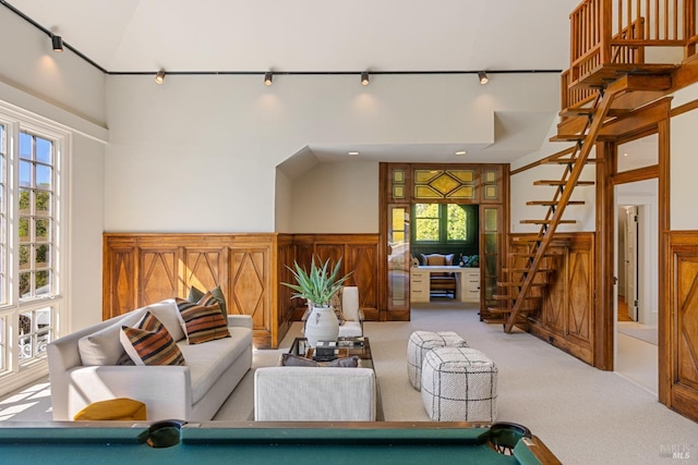 interior space with pool table, a decorative wall, a towering ceiling, and a wainscoted wall