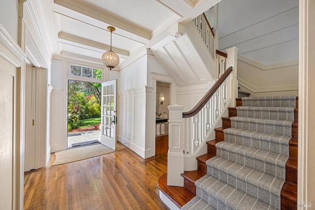entryway with a decorative wall, wood finished floors, and stairs