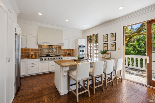 kitchen with a kitchen bar, stainless steel appliances, dark wood-type flooring, custom range hood, and backsplash