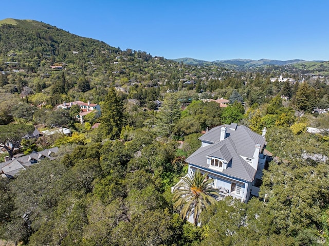 drone / aerial view featuring a wooded view and a mountain view