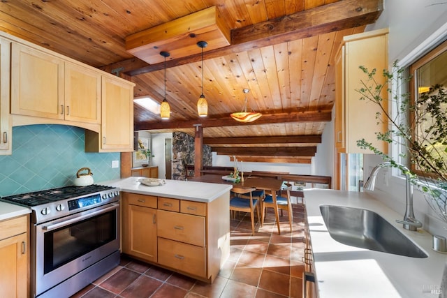kitchen featuring a peninsula, stainless steel range with gas stovetop, beam ceiling, tasteful backsplash, and a sink