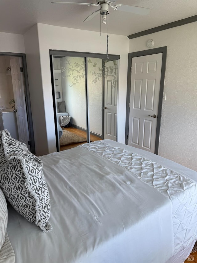 bedroom featuring a closet, a textured wall, and a ceiling fan