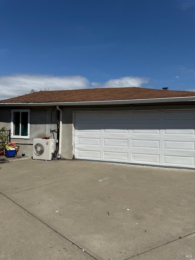 garage featuring driveway and ac unit