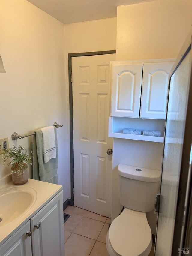 bathroom featuring tile patterned flooring, vanity, and toilet