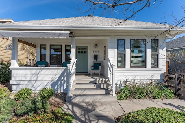 view of front of home featuring an attached carport, a porch, and a shingled roof